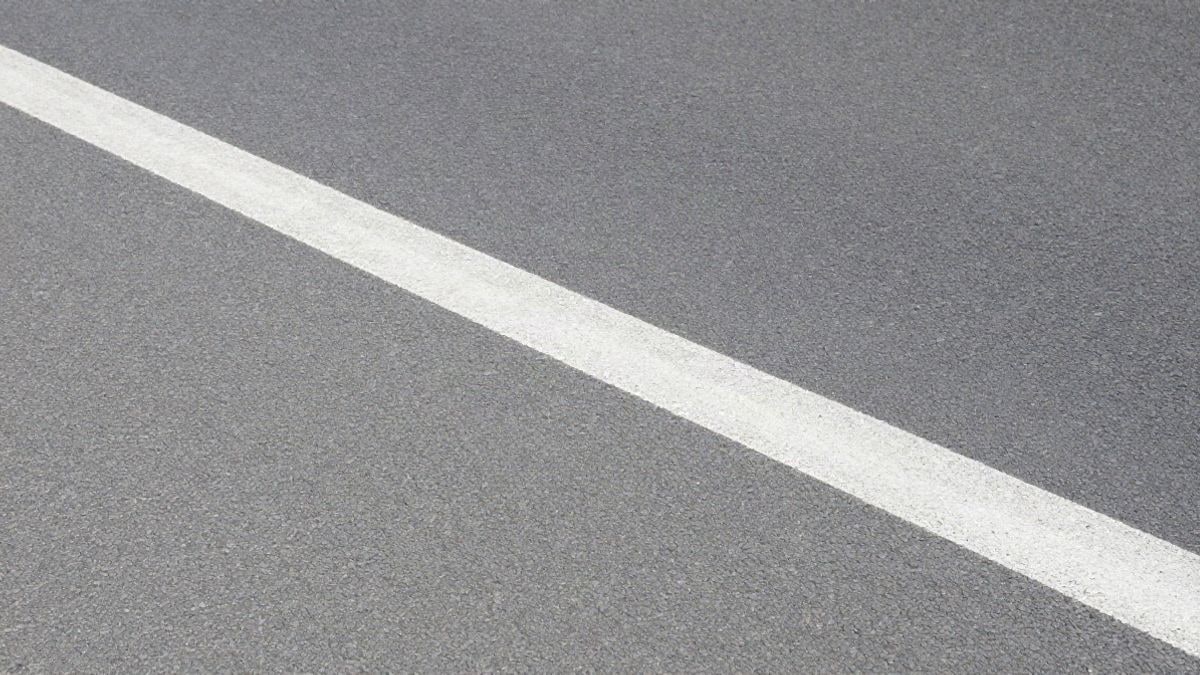 Illustrative image: worn asphalt surface with a solid white line painted on a regular road