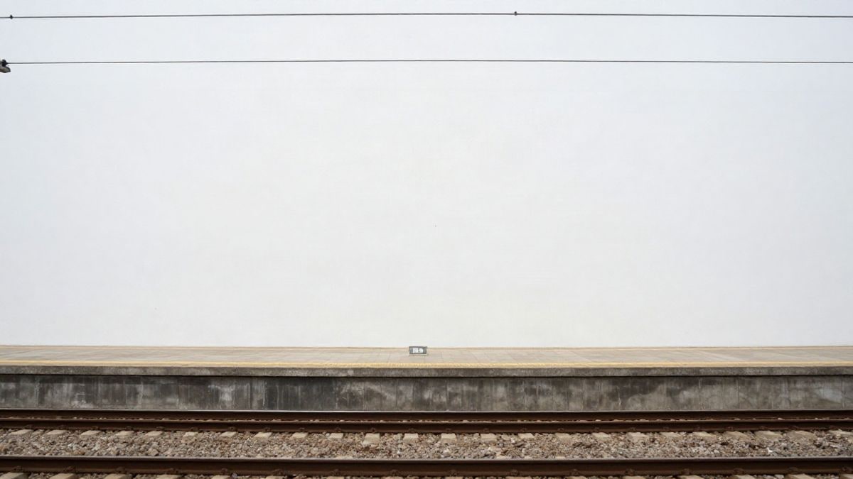 Imagen ilustrativa: andén ferroviario vacío con una línea amarilla de seguridad y un poste de catenaria al fondo