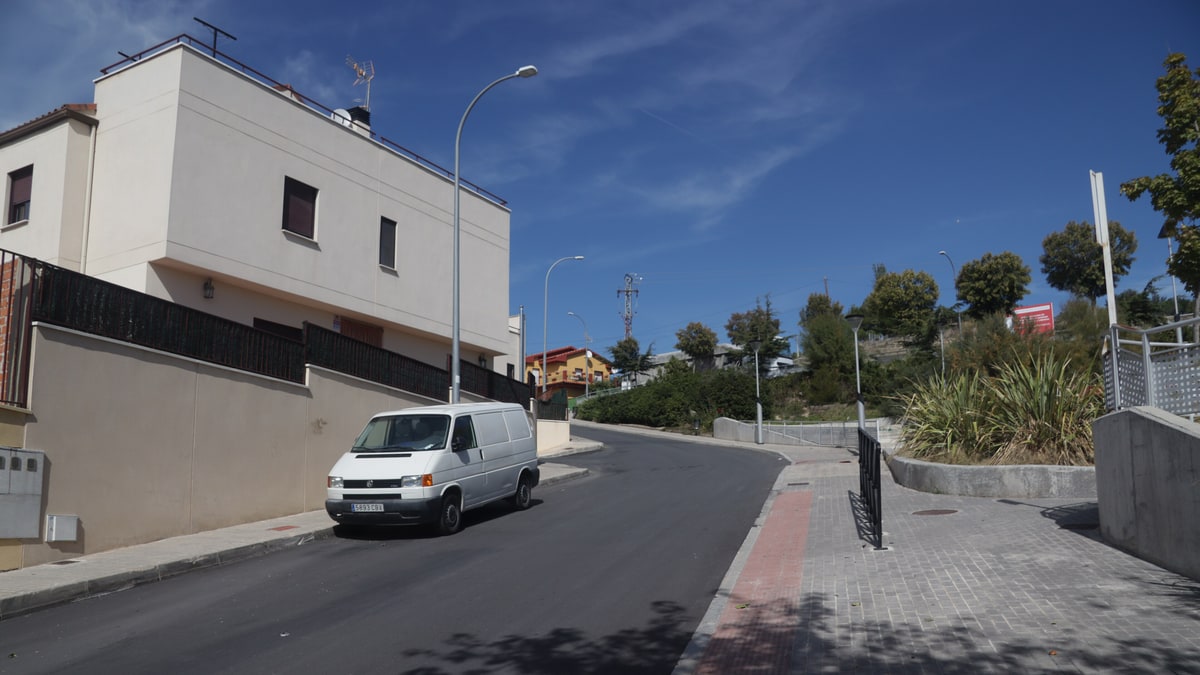 Calle residencial asfaltada con acera adoquinada, farolas y una furgoneta blanca aparcada en Morata