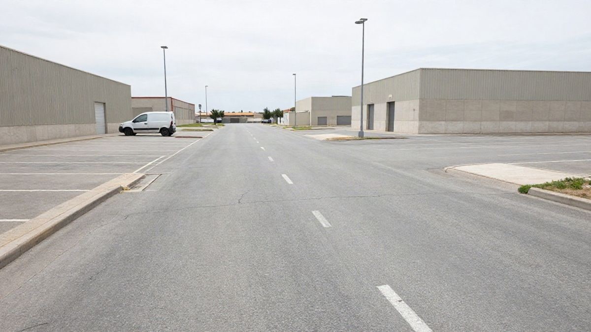 Illustrative image: empty parking lot in a generic industrial estate with a van in the background