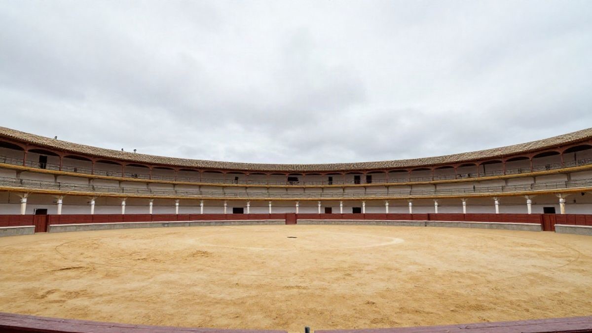 Illustrative image: empty bullring with sand and sky in the background