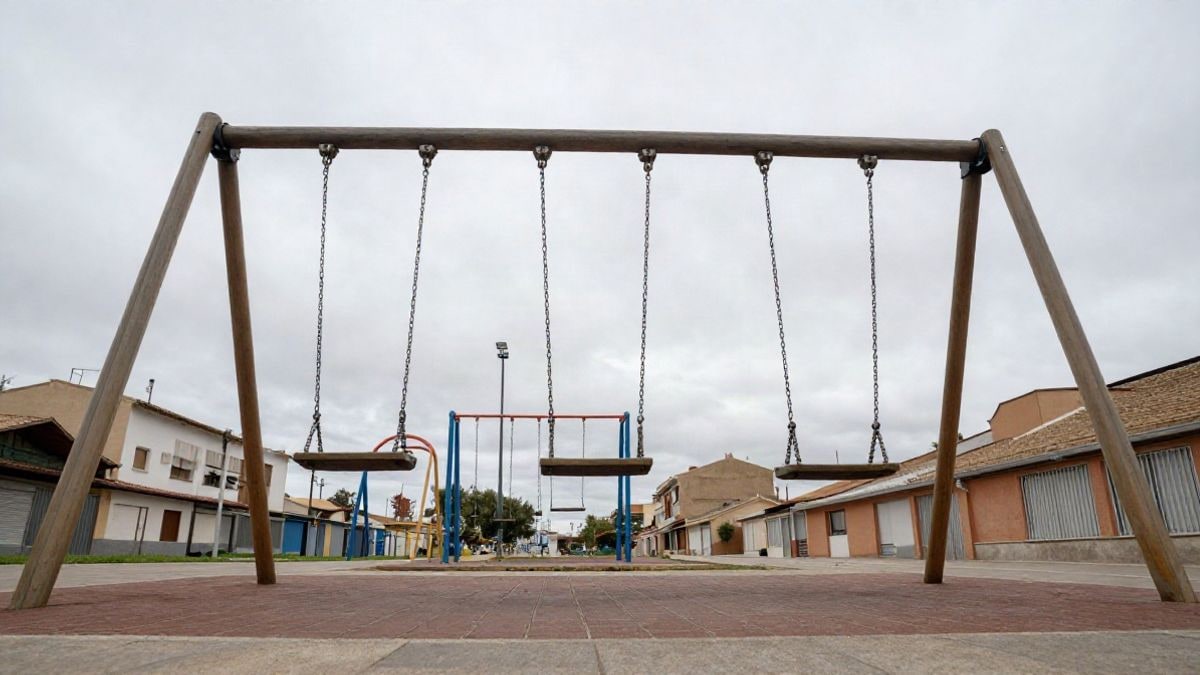 Illustrative image: schoolyard with empty swings under a cloudy sky