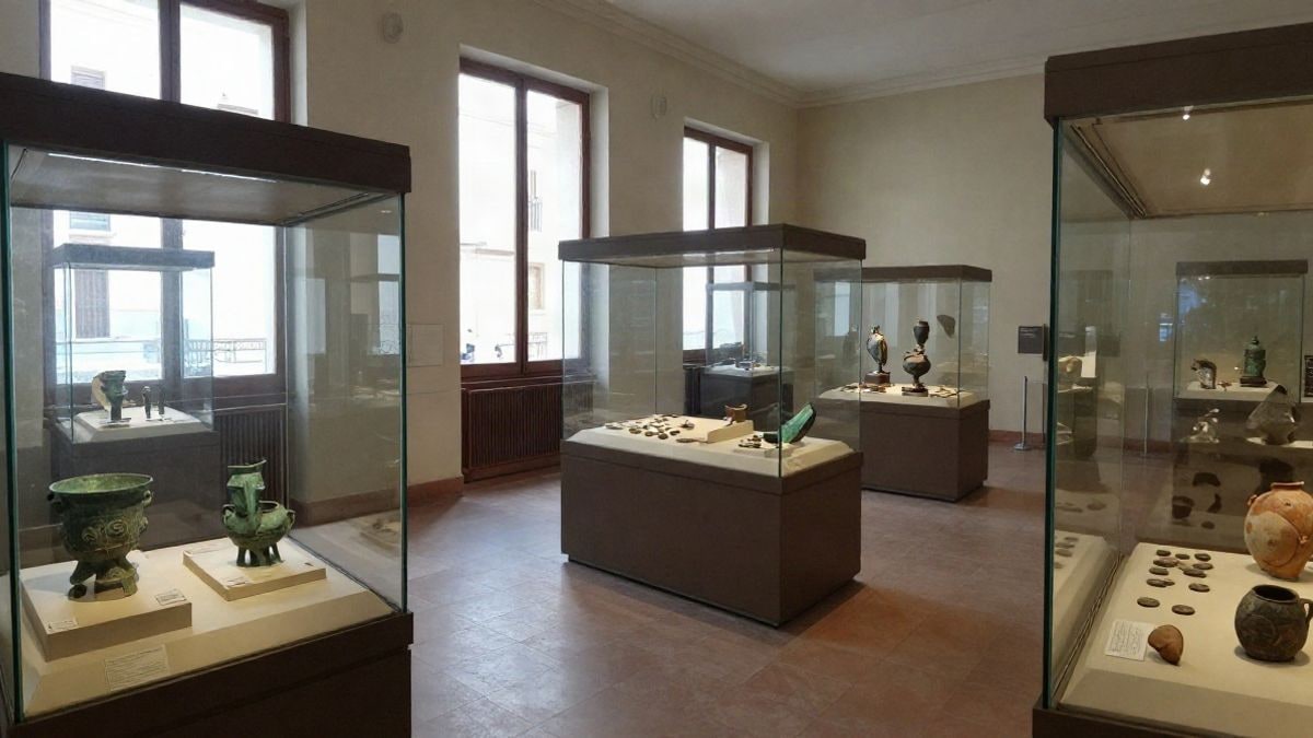 Imagen ilustrativa: vitrinas de un museo arqueológico con piezas romanas de bronce y cerámica