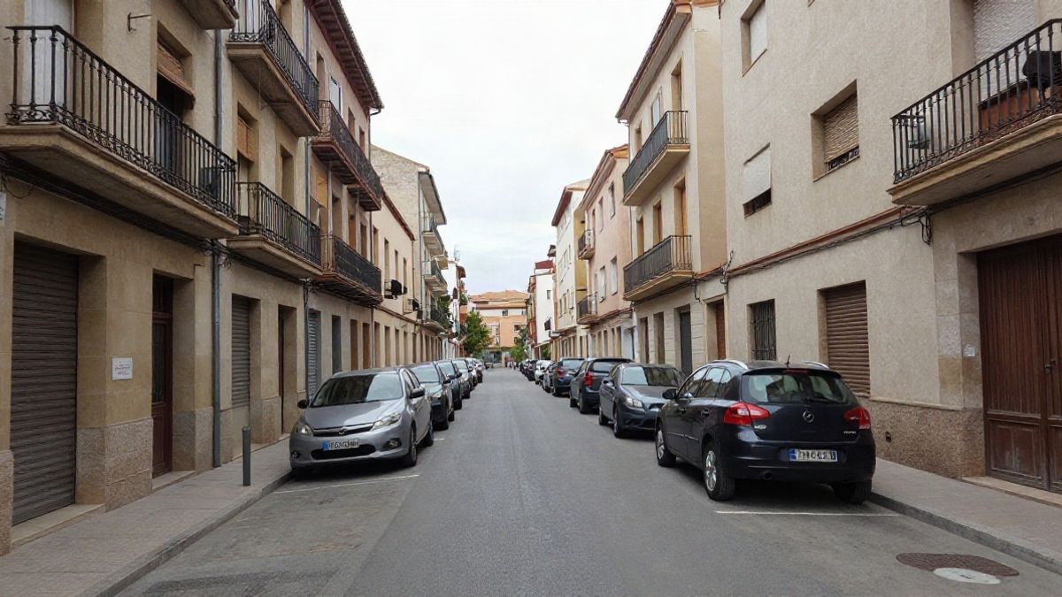 Imagen ilustrativa: calle residencial corriente con fachadas de pisos y coches aparcados a la luz del día
