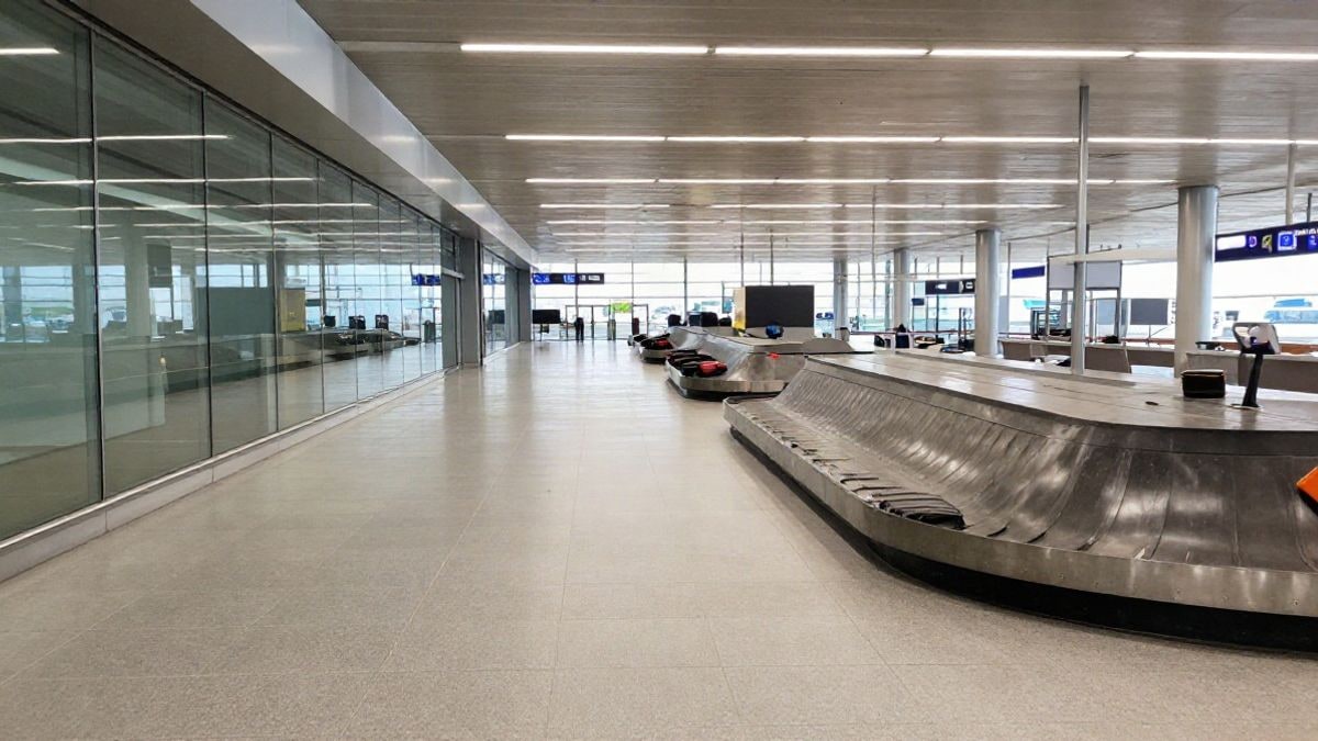 Illustrative image: generic arrivals corridor of a modern airport with glass walls and daylight