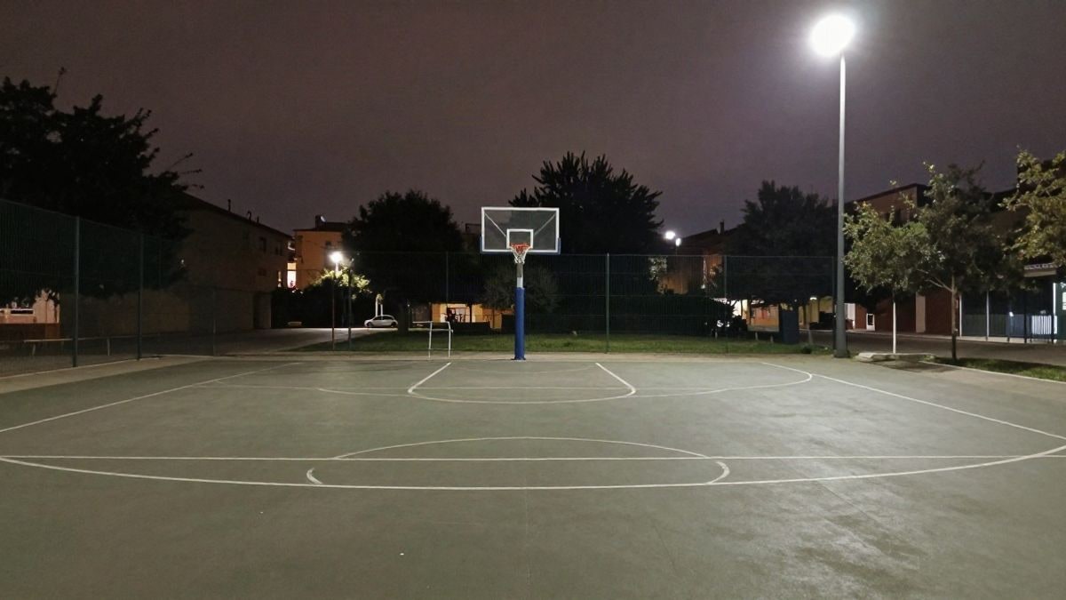 Imagen ilustrativa: canasta de baloncesto vacía bajo focos nocturnos