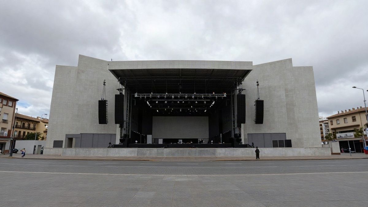 Illustrative image: facade of a modern auditorium viewed from a low angle with cloudy sky