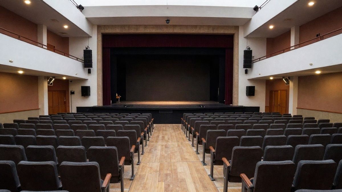 Illustrative image: wide-angle view of a municipal theatre with empty seats and a lit stage