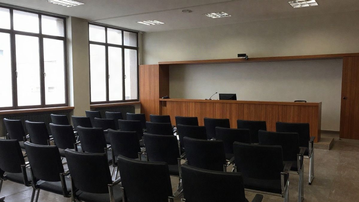 Imagen ilustrativa: sala de conferencias moderna con sillas vacías y atril frente a una ventana lateral