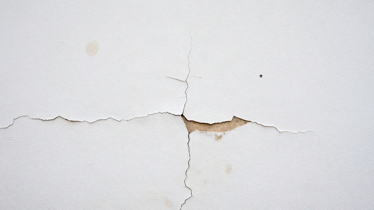 Imagen ilustrativa: primer plano de una pared agrietada con manchas de humedad y pintura desconchada