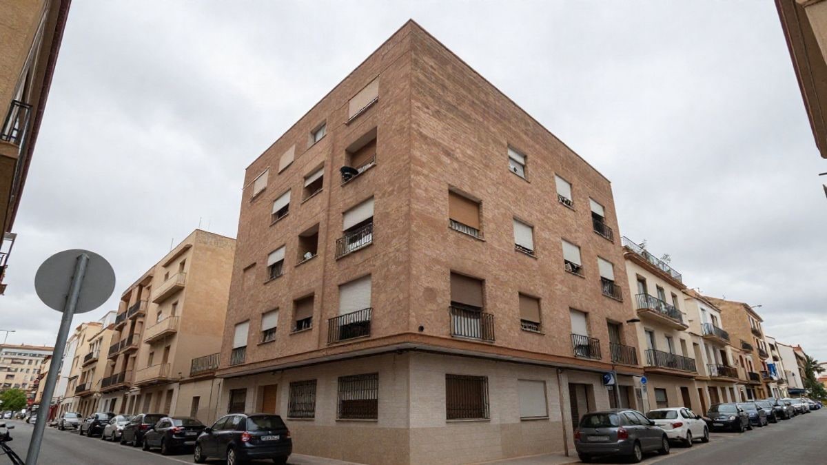 Imagen ilustrativa: fachada de un edificio de viviendas visto desde la calle bajo un cielo nublado