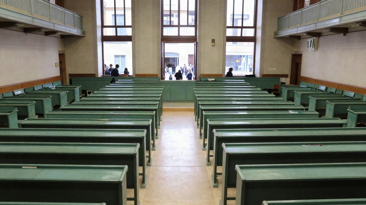Imagen ilustrativa: interior de un hemiciclo parlamentario vacío con escaños verdes y tribuna al fondo