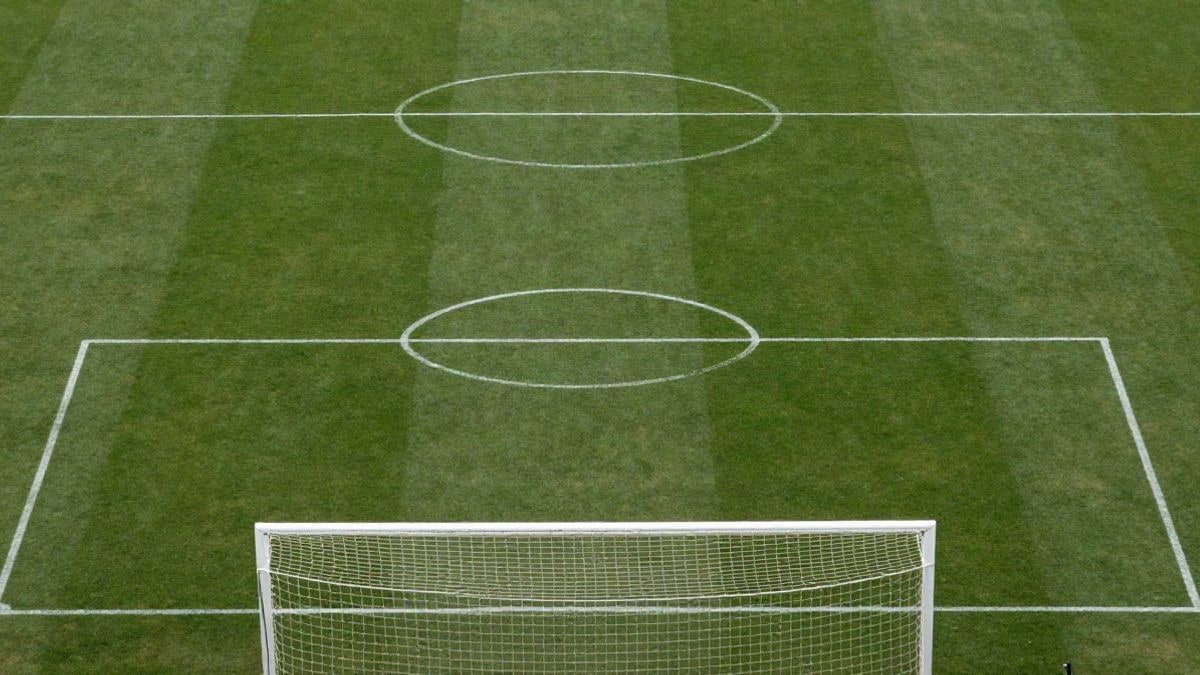 Imagen ilustrativa: vista cenital de un campo de fútbol con líneas blancas y una portería con red