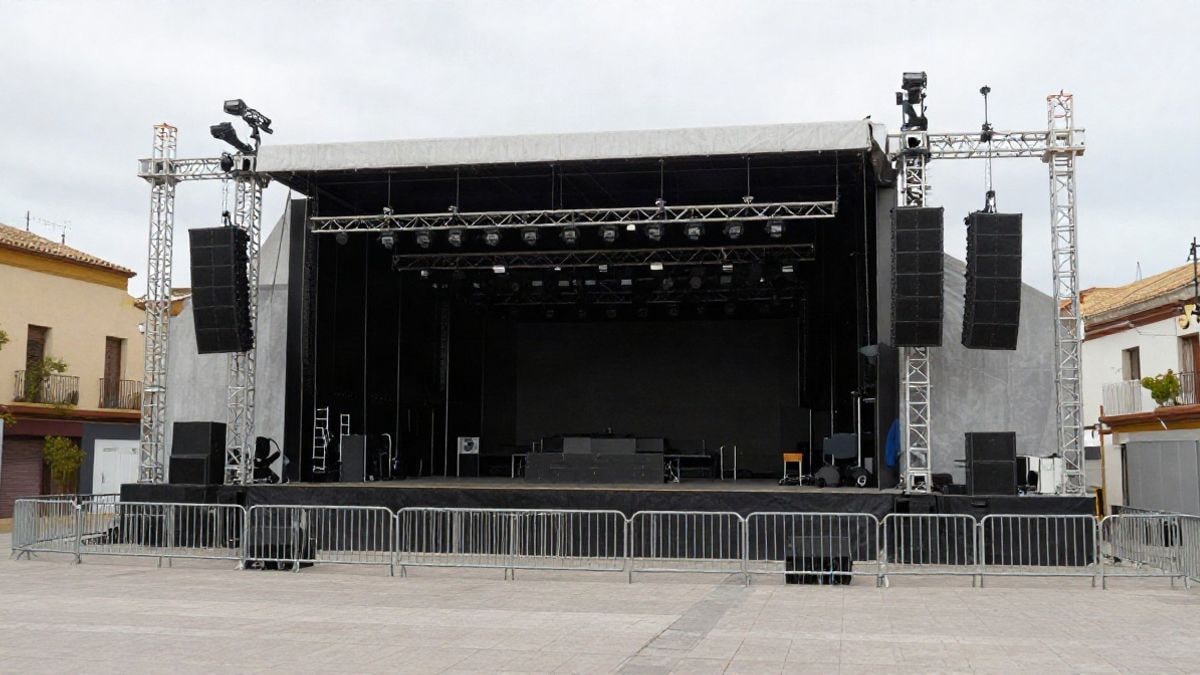 Imagen ilustrativa: vista lateral de un recinto de conciertos al aire libre con escenario y vallas, sin público