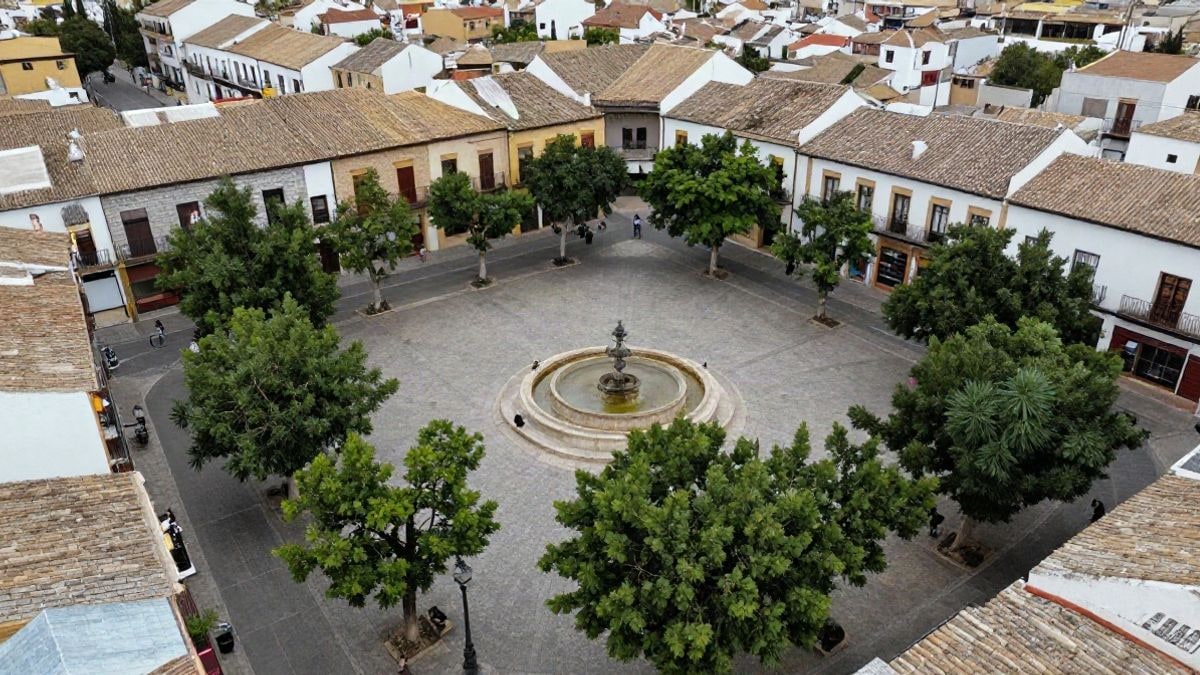Illustrative image: aerial view of a Spanish square with a fountain and trees