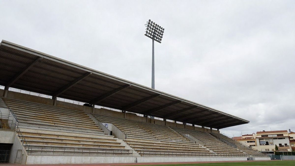 Illustrative image: low angle of an empty stadium stand with floodlights and cloudy sky