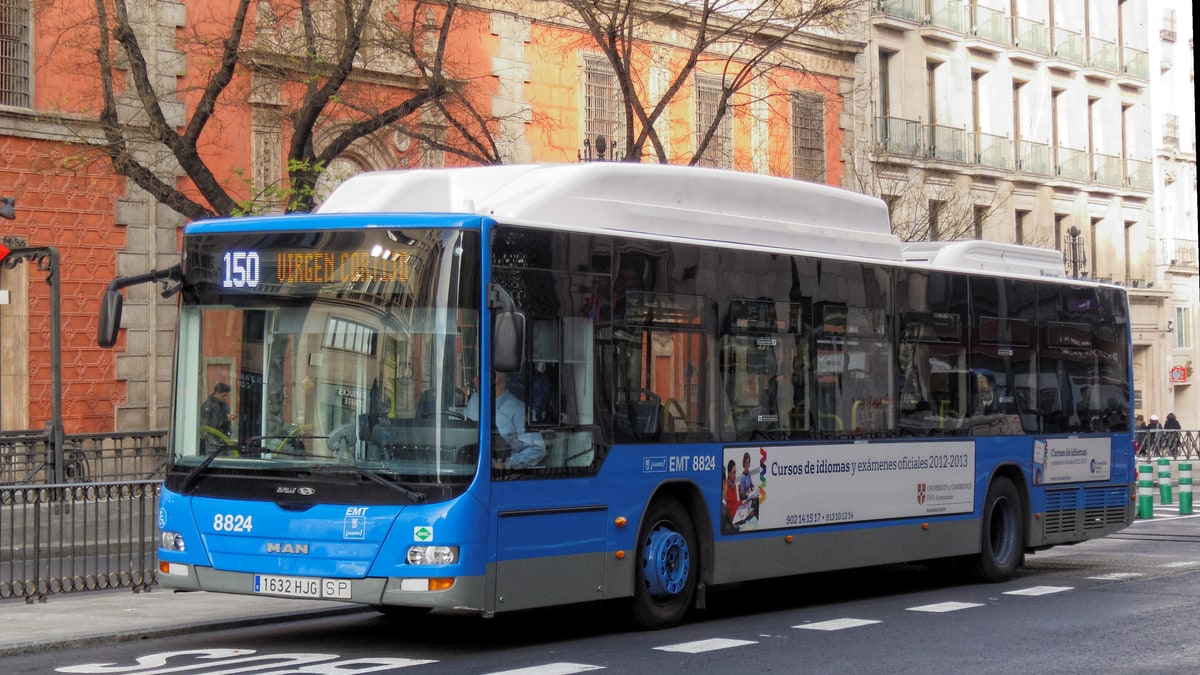 EMT blue bus 8824 from line 150 travelling through a central street in Madrid